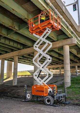 A Snorkel Narrow Rough Terrain Scissor Lift bring used.
